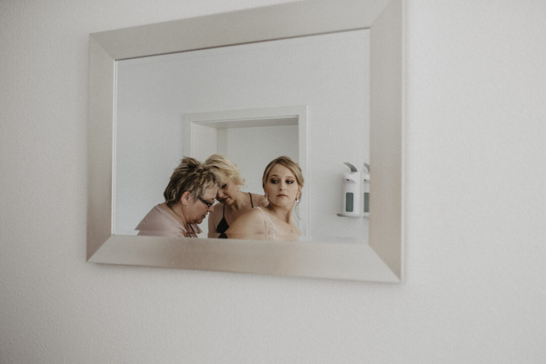 Spiegelaufnahme beim Ankleiden der Braut – emotionale Momentaufnahme im Getting Ready