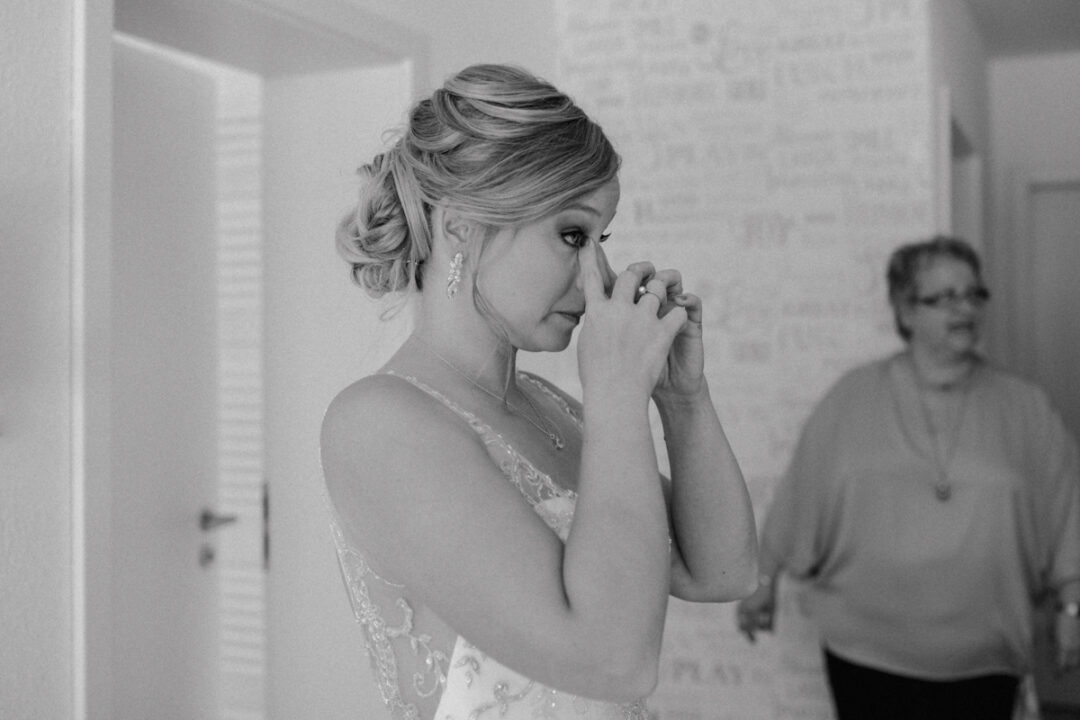 Braut wischt sich gerührt die Tränen – emotionale Hochzeitsvorbereitung