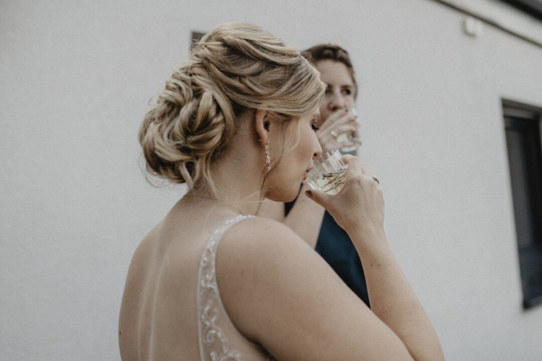 Braut und Freundin stoßen mit Sekt an – Feierlicher Start in den Hochzeitstag