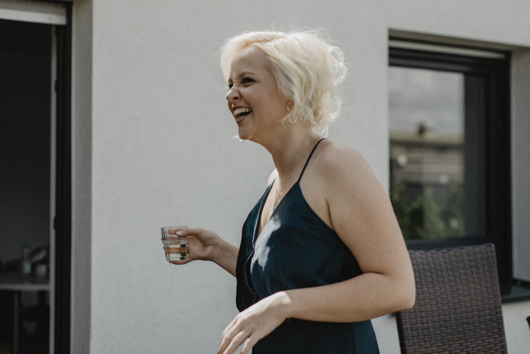 Lachende Brautjungfer im Außenbereich – lockere Stimmung am Hochzeitstag