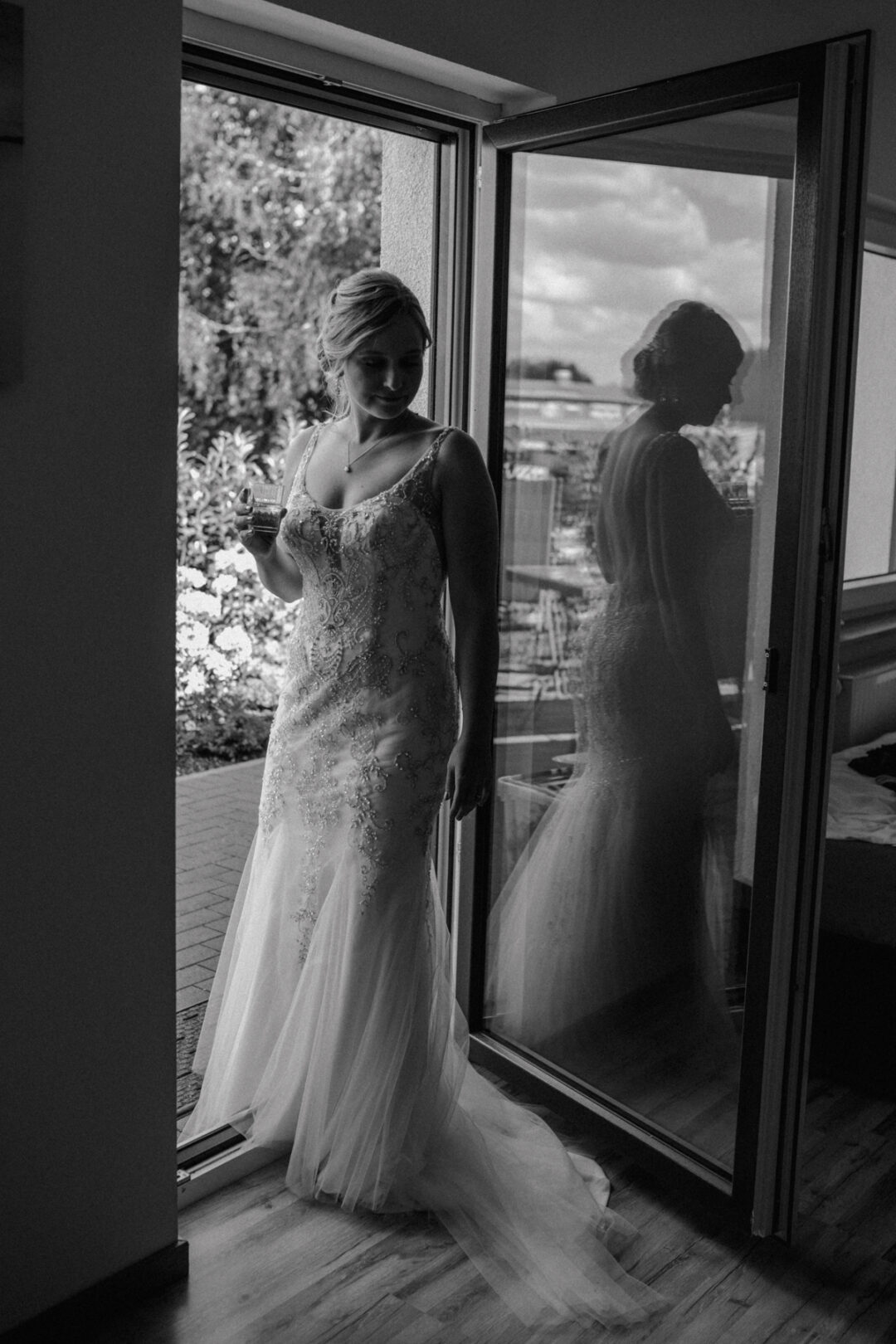 Braut mit Reflexion im Fenster – stille Gedanken vor der Hochzeit