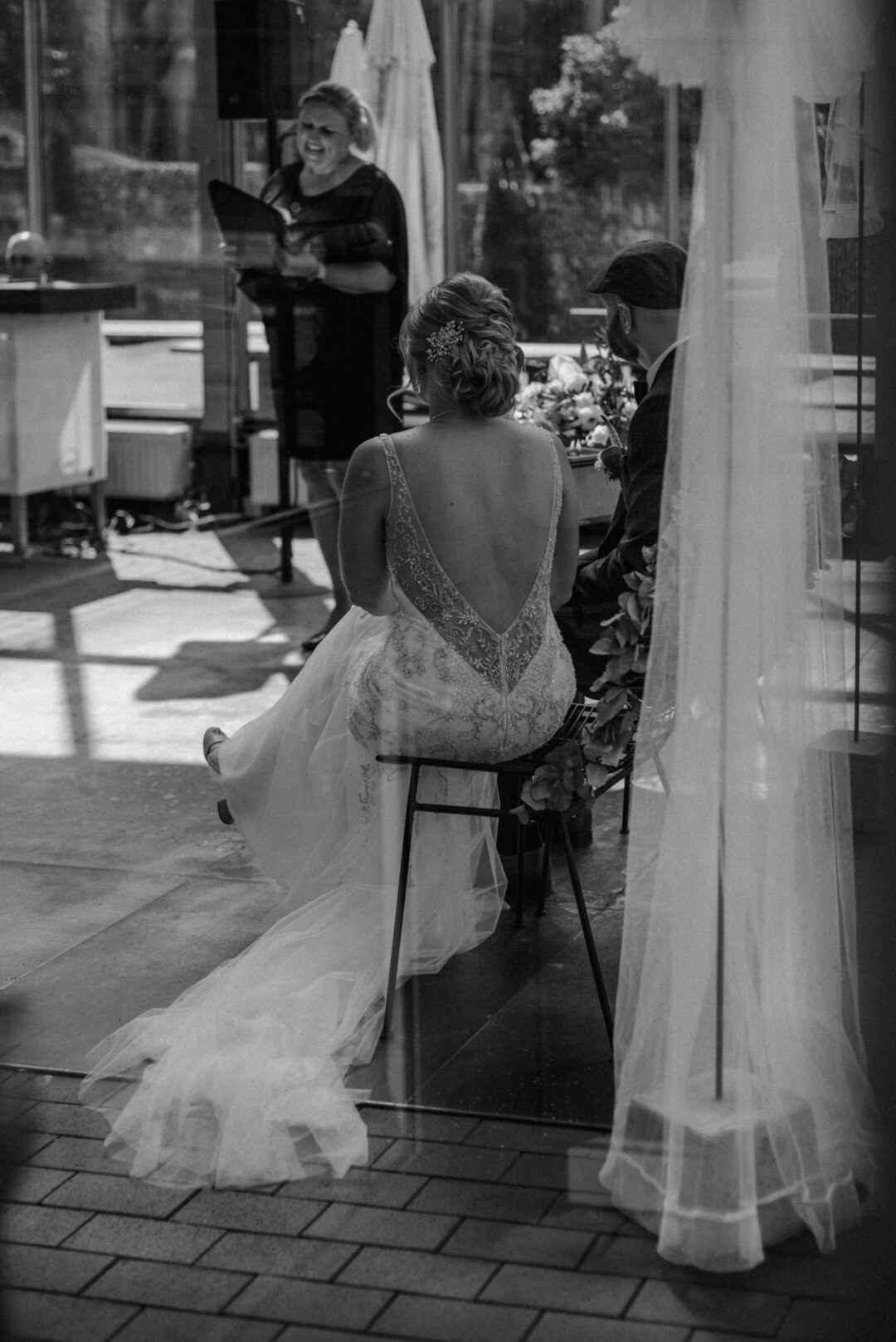 Blick von hinten auf das Brautpaar während der Zeremonie mit der freien Rednerin im Kraftwerk Relax