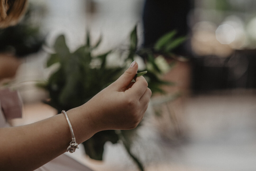 Nahaufnahme der kleinen Hand eines Blumenmädchens mit einem Blatt – ruhiger Moment während der Zeremonie