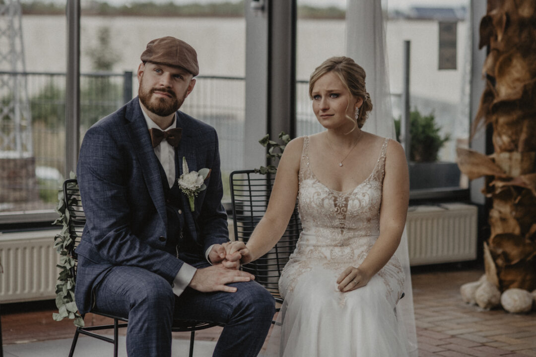 Brautpaar hält sich an den Händen während eines bewegenden Moments der freien Trauung im Kraftwerk Relax