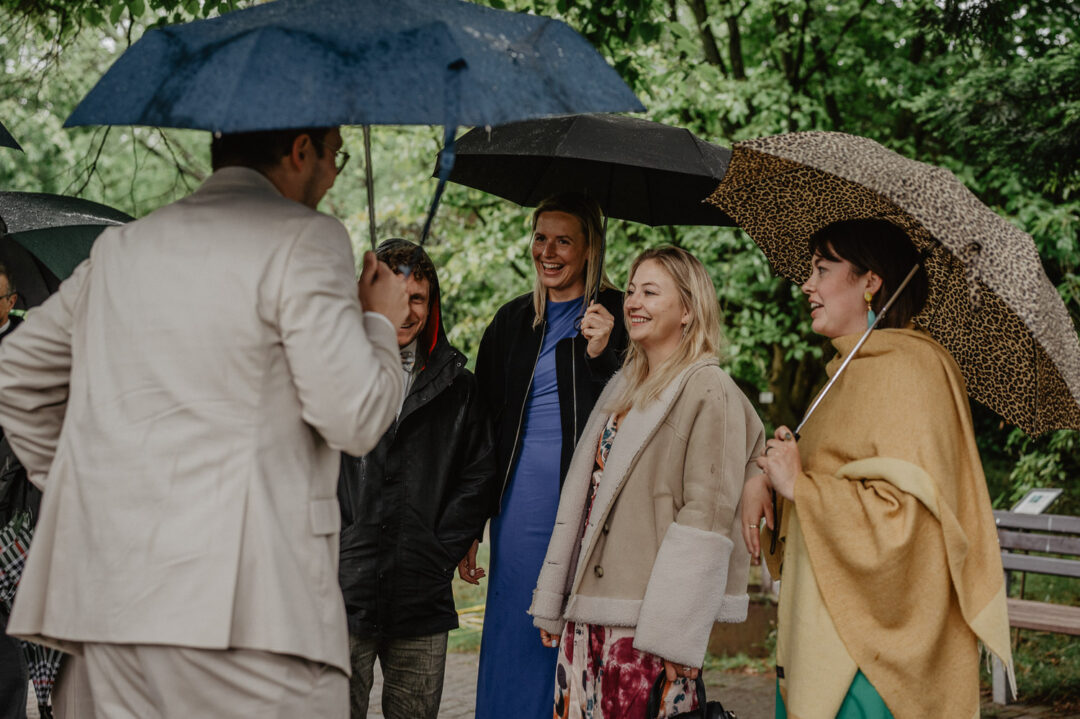 Hochzeitsgäste mit Regenschirmen im Botanischen Garten Osnabrück