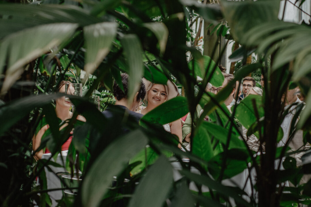 Braut durch Blätter im Regenwaldhaus fotografiert