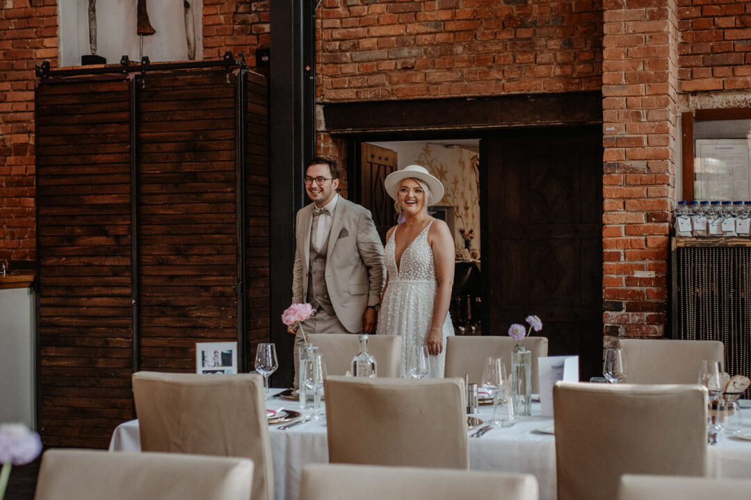 Brautpaar betritt lachend den Hochzeitssaal