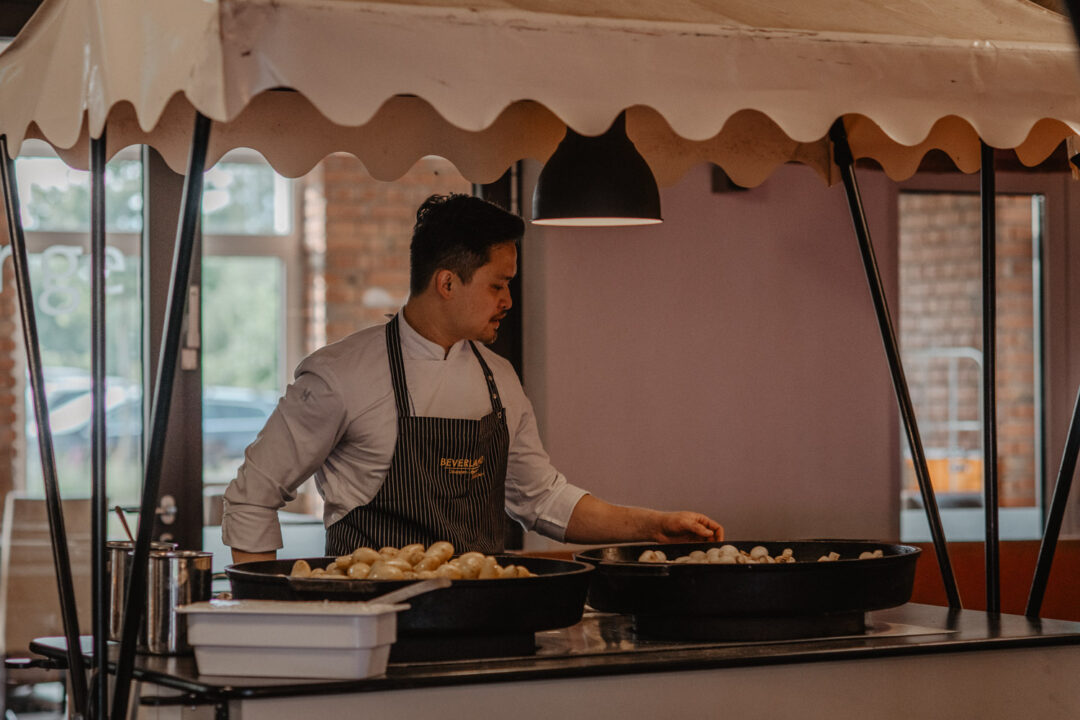 Koch bereitet Speisen beim Buffet im Beverland zu