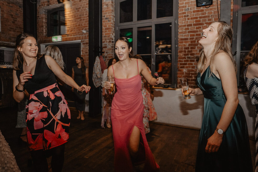 Lachende Gäste tanzen bei der Hochzeitsparty