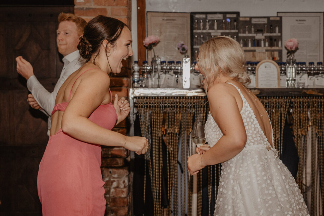 Braut tanzt mit Schwester bei der Hochzeitsfeier