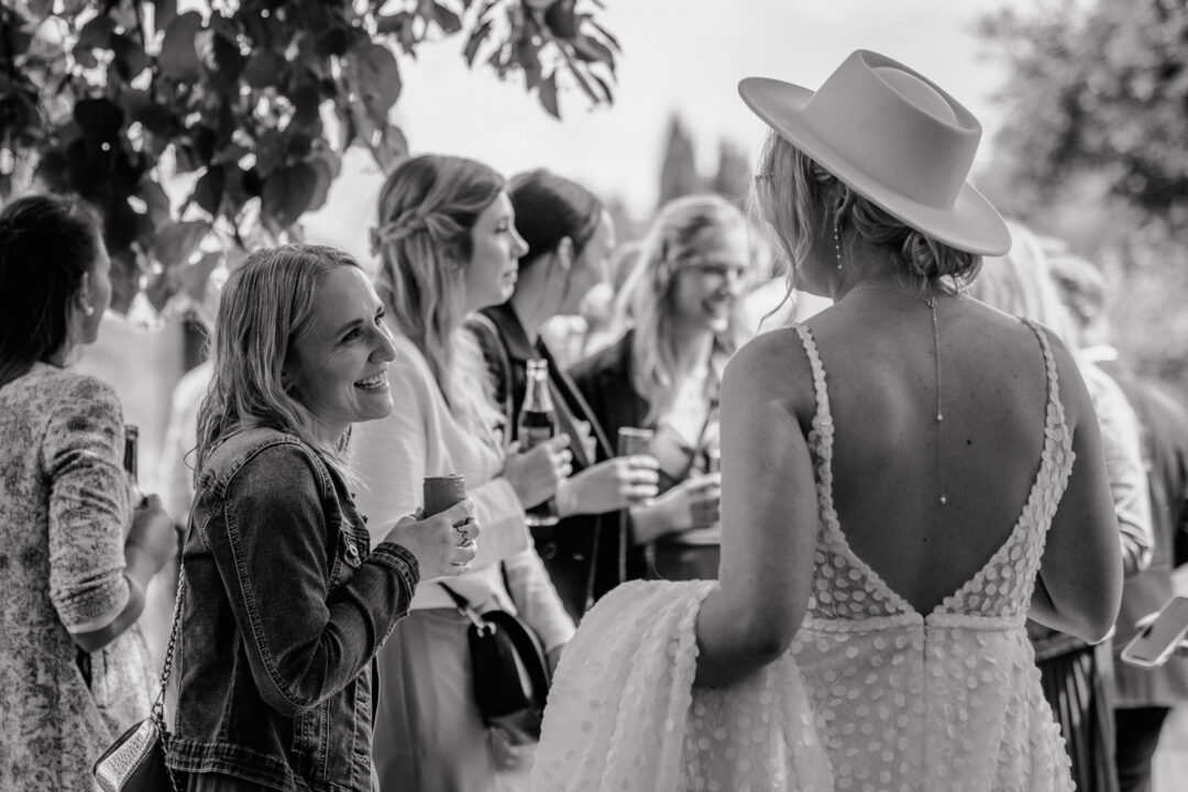Braut unterhält sich mit Freundin bei der Gartenhochzeit