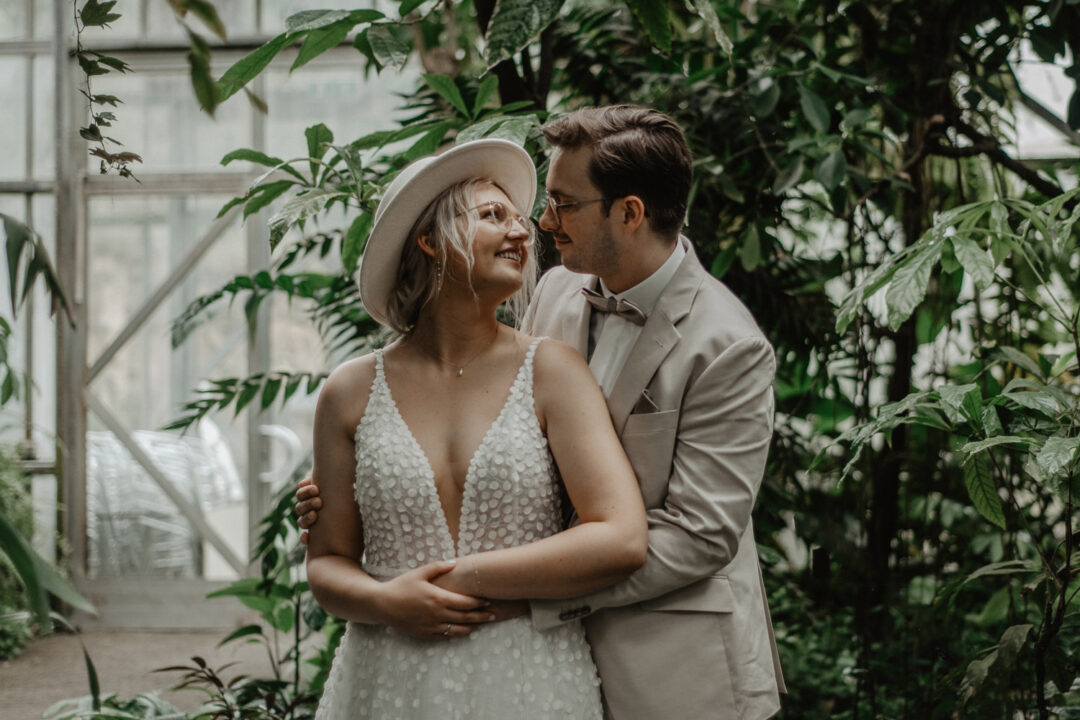 Bräutigam umarmt lachende Braut im Tropenhaus Osnabrück