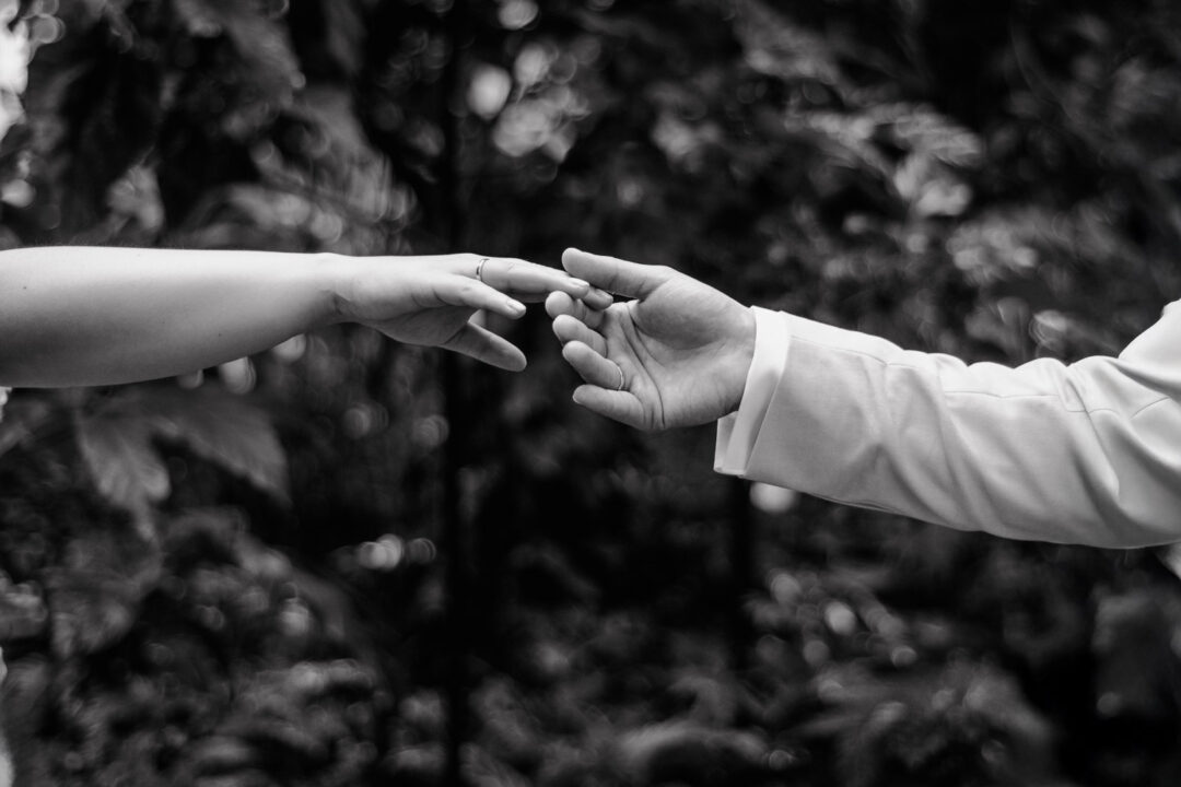 Hände von Braut und Bräutigam berühren sich zärtlich