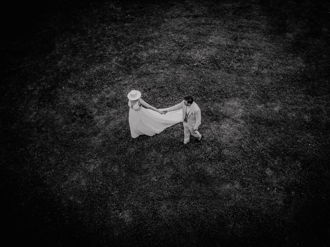 Brautpaar läuft über die Wiese in Schwarzweiß