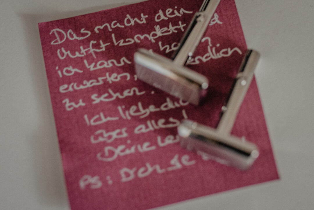 Manschettenknöpfe und persönliche Notiz beim Getting Ready des Bräutigams.