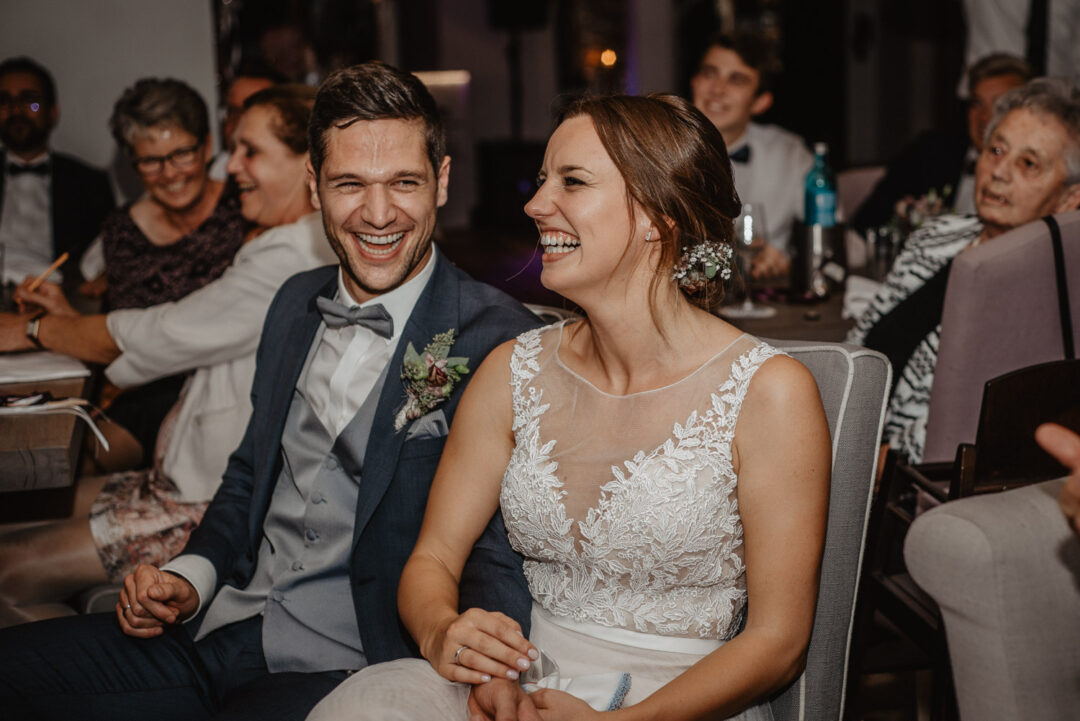 Braut und Bräutigam lachen ausgelassen bei der Feier in Dortmund.