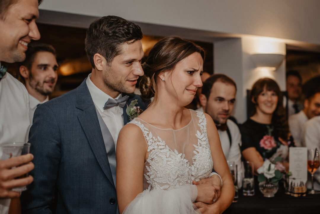 Bräutigam hält seine Braut im Arm, sie wirkt bewegt.