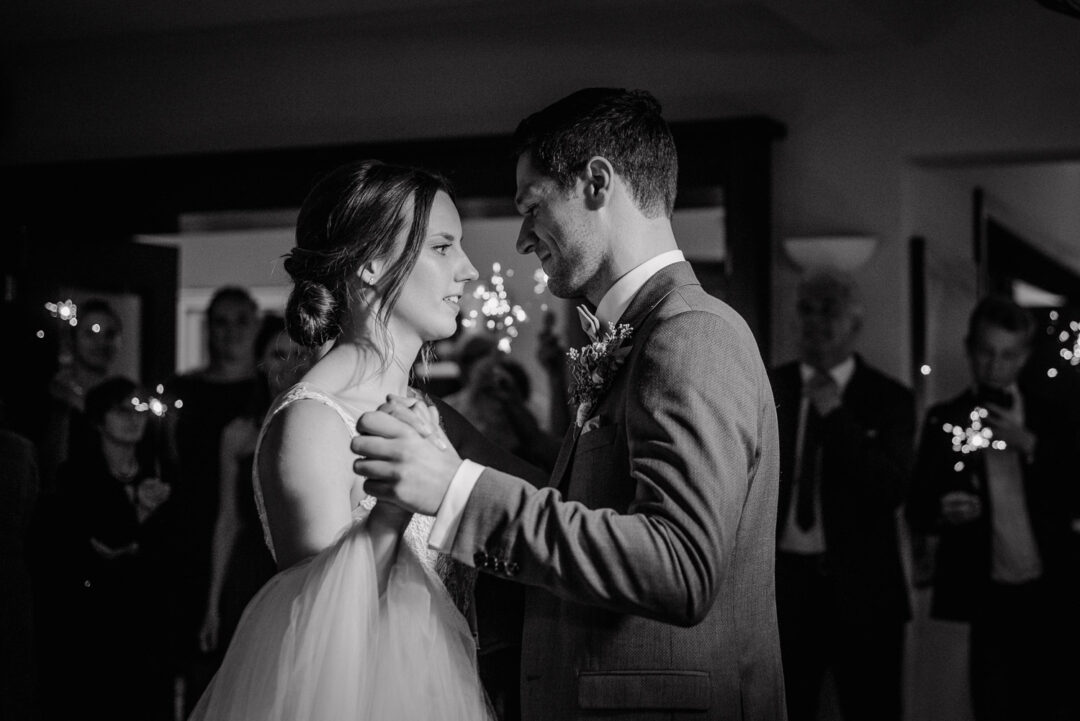 Braut und Bräutigam tanzen eng umschlungen, Schwarz-Weiß Aufnahme.