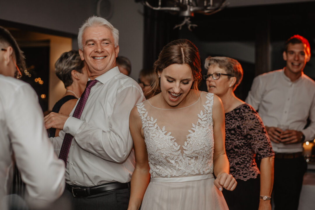 Die Braut Lena tanzt ausgelassen mit Gästen bei der Hochzeitsfeier im Gasthaus Stromberg.