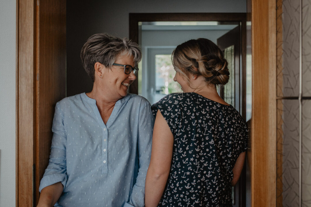 Fröhliches Gespräch zwischen Braut und Mutter beim Getting Ready.