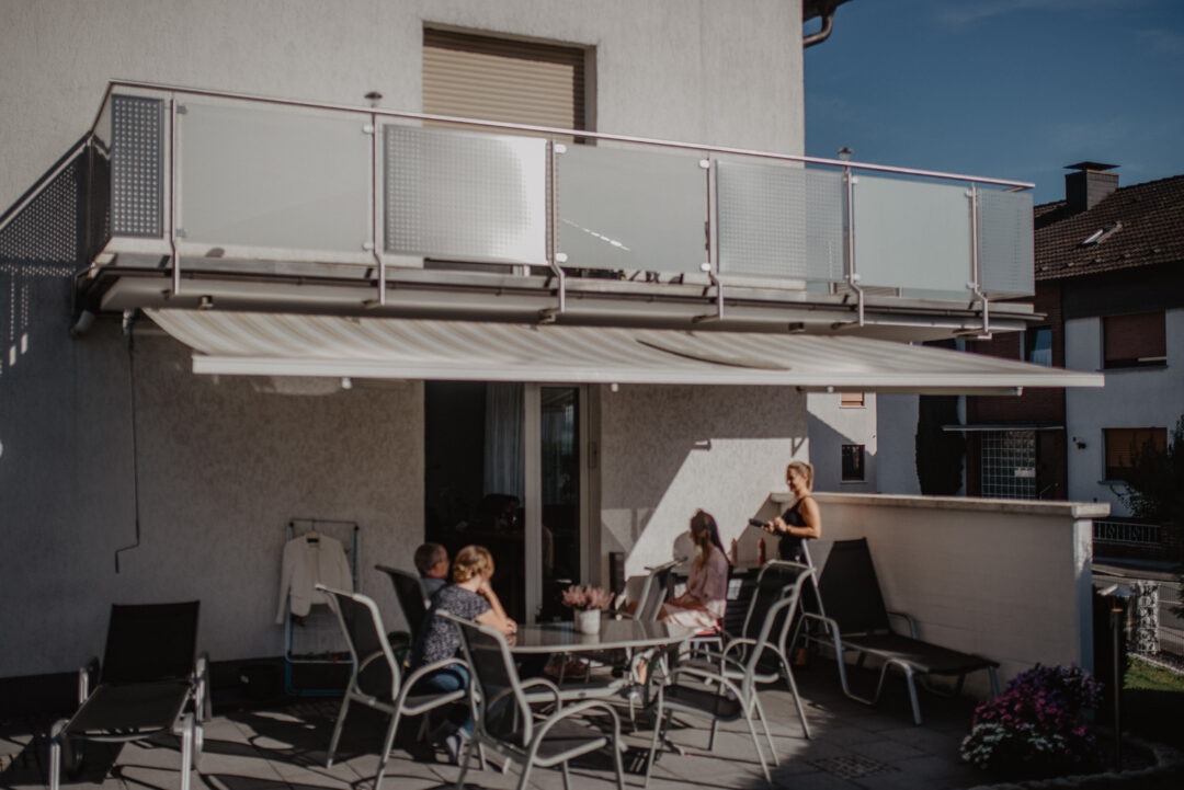 Familie sitzt gemeinsam auf der Terrasse während des Getting Ready.