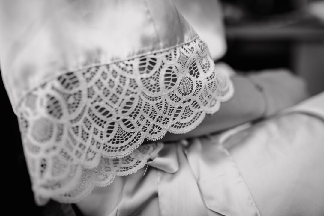 Detailaufnahme der Spitzenärmel vom Morgenmantel der Braut, Schwarz-Weiß.