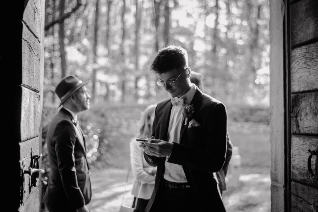Hochzeitsgäste warten vor der Kirche auf die Trauung, Schwarz-Weiß.