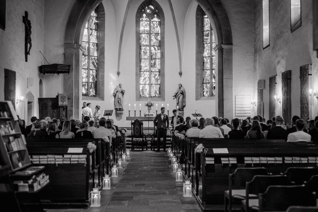 Gäste sitzen in der Kirche und warten auf die Braut, Schwarz-Weiß.