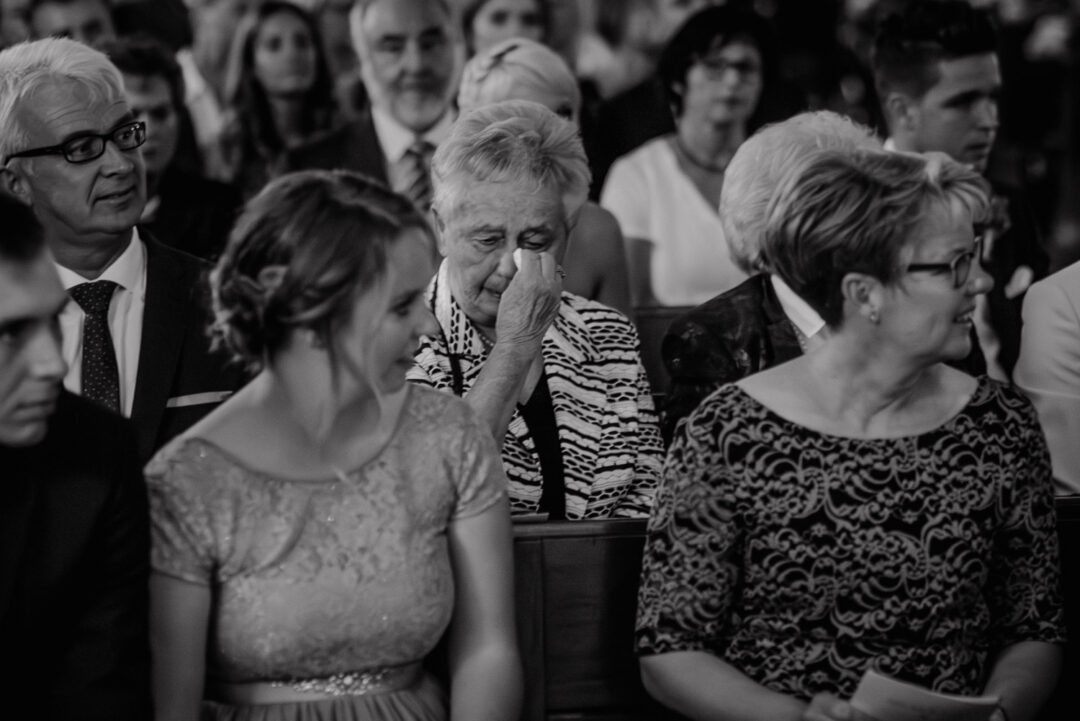 Ältere Dame wischt sich während der Trauung die Tränen, Schwarz-Weiß.