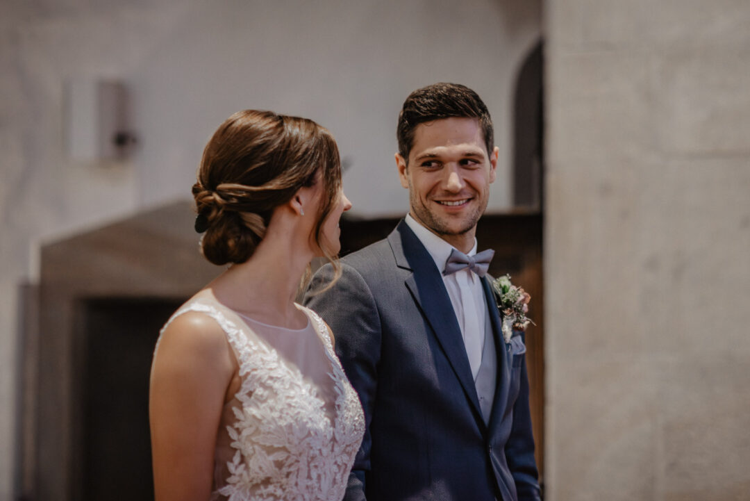 Braut und Bräutigam schauen sich verliebt während der Trauung an.