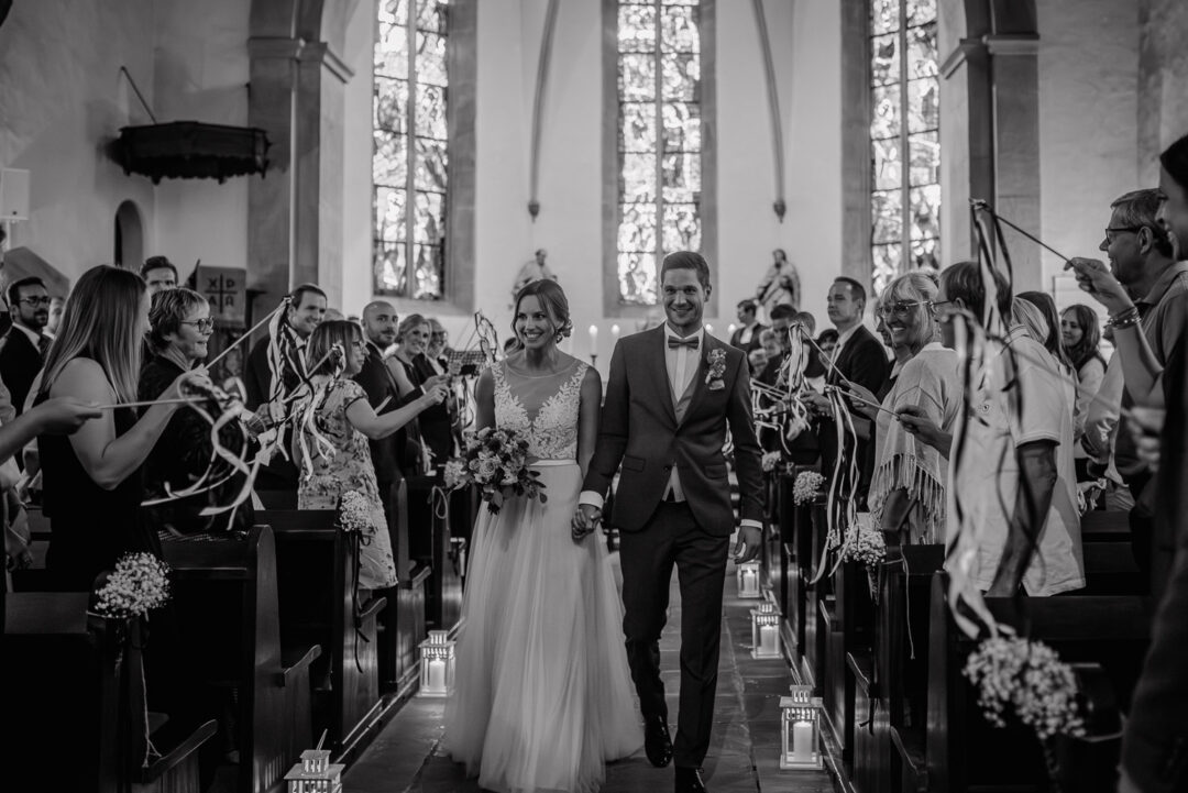 Braut und Bräutigam ziehen nach der Trauung durch die Kirche aus, Schwarz-Weiß.