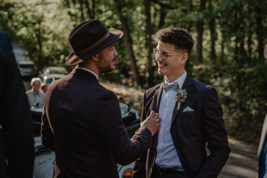 Gäste unterhalten sich lachend vor der Kirche nach der Trauung.