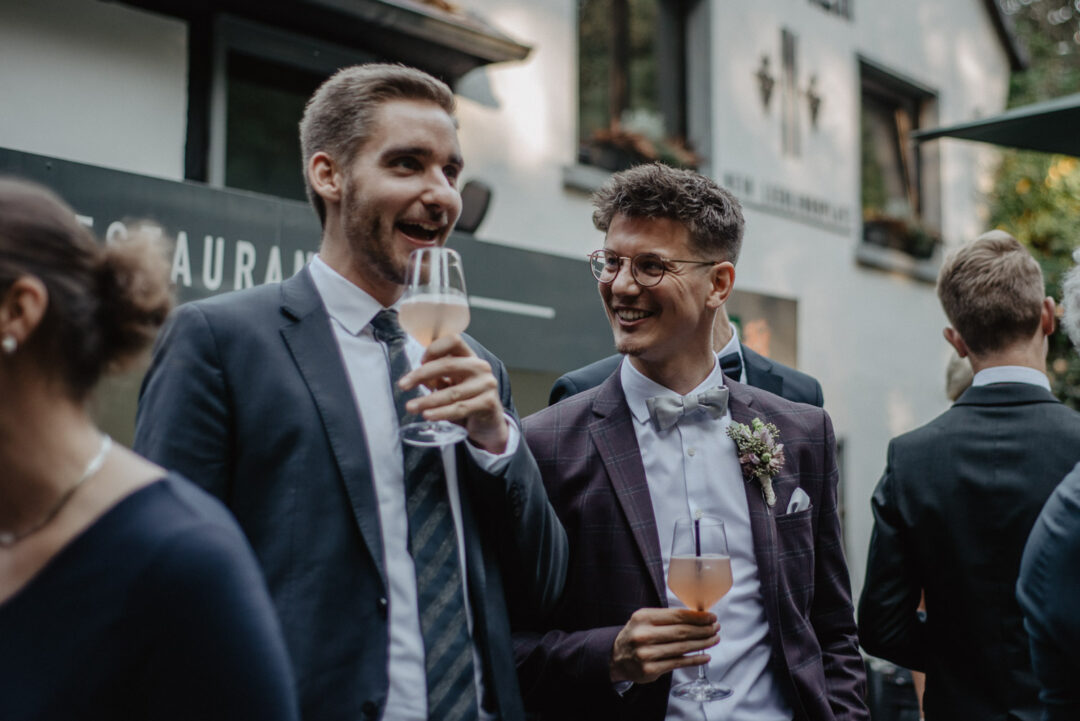 Gäste stoßen mit Gläsern beim Empfang im Wirtshaus Krämer an.