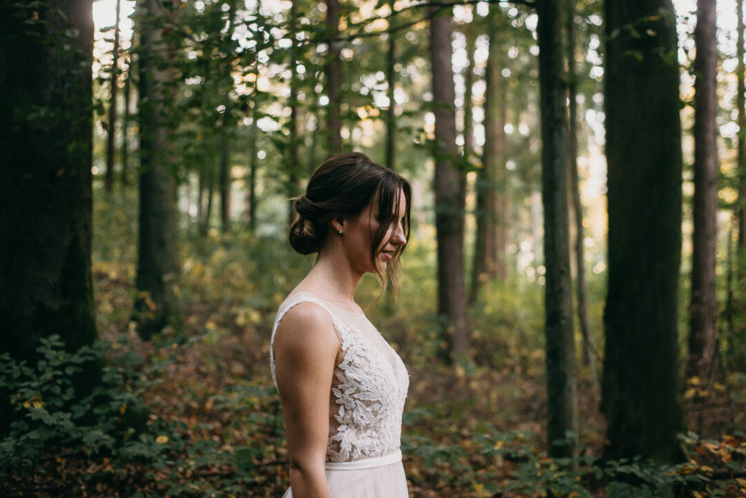 Portrait der Braut im Wald mit elegant hochgestecktem Haar.
