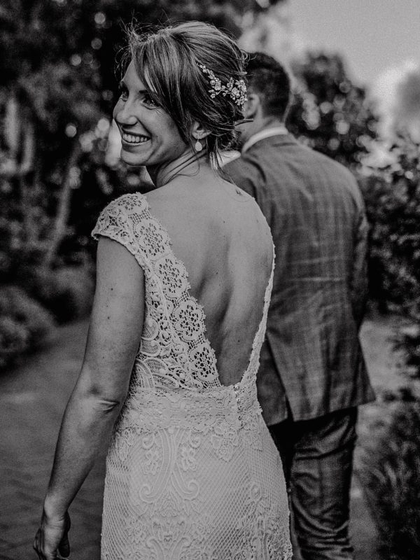 Lachende Braut im Spitzenkleid bei Hochzeit in Schwarzweiß