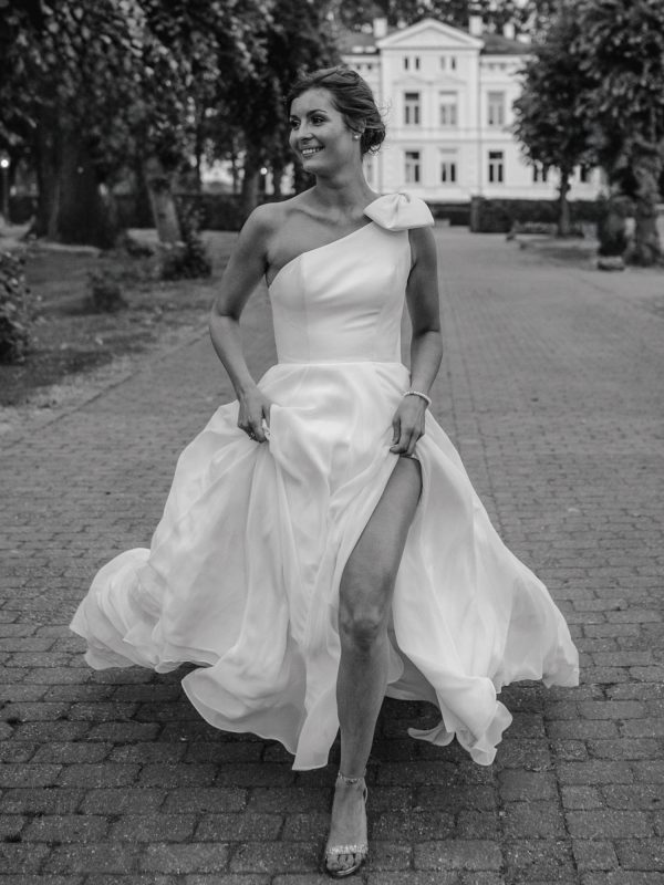 Elegante Braut in Bewegung mit modernem Kleid in Schwarzweiß